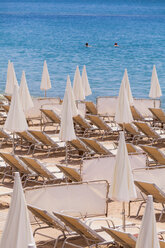 France, Cote d'Azur, Cannes, sun loungers and beach umbrellas on beach - WDF002717