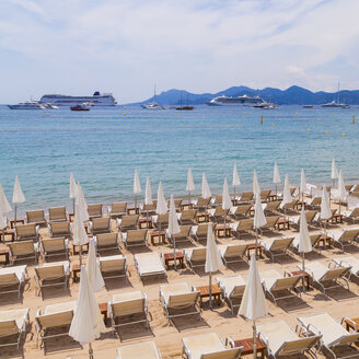 Frankreich, Côte d'Azur, Cannes, Liegestühle und Sonnenschirme am Strand - WDF002718