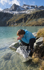 Austria, Salzburg State, Pinzgau, woman at drinking water from Weisssee mountain lake - MKFF000133