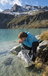 Österreich, Bundesland Salzburg, Pinzgau, Frau am Trinkwasser aus dem Weisssee - MKFF000133