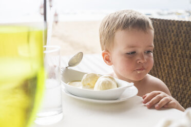 Mexiko, Porträt eines Kleinkindes, das an einem Tisch sitzt und Eis isst - ABAF001530