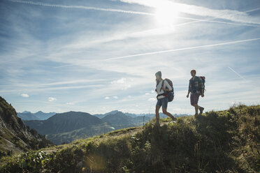 Austria, Tyrol, Tannheimer Tal, young couple hiking on mountain trail - UUF002197