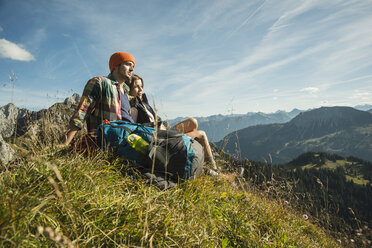 Österreich, Tirol, Tannheimer Tal, junges Paar beim Ausruhen in den Bergen - UUF002193