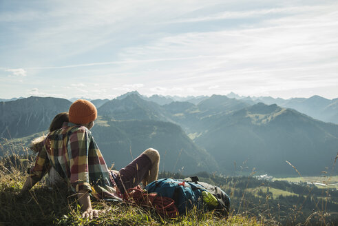 Österreich, Tirol, Tannheimer Tal, junges Paar beim Ausruhen in den Bergen - UUF002192