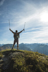 Austria, Tyrol, Tannheimer Tal, young man cheering on mountain top - UUF002182