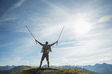 Austria, Tyrol, Tannheimer Tal, young man cheering on mountain top - UUF002181