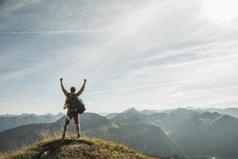 Austria, Tyrol, Tannheimer Tal, young man cheering on mountain top stock photo