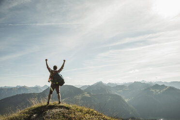 Austria, Tyrol, Tannheimer Tal, young man cheering on mountain top - UUF002179