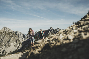 Österreich, Tirol, Tannheimer Tal, junges Paar beim Wandern am Felsen - UUF002172