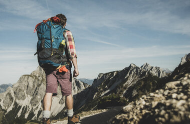 Austria, Tyrol, Tannheimer Tal, young man hiking on mountain trail - UUF002171