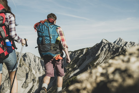 Österreich, Tirol, Tannheimer Tal, junges Paar beim Wandern am Felsen, lizenzfreies Stockfoto