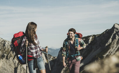 Österreich, Tirol, Tannheimer Tal, junges Paar beim Wandern am Felsen - UUF002169