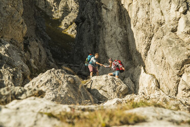 Österreich, Tirol, Tannheimer Tal, junges Paar beim Wandern am Felsen - UUF002155