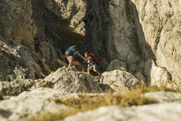 Österreich, Tirol, Tannheimer Tal, junges Paar beim Wandern am Felsen - UUF002153