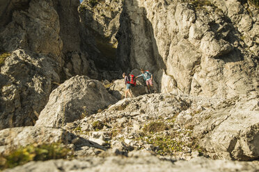 Österreich, Tirol, Tannheimer Tal, junges Paar beim Wandern am Felsen - UUF002152