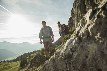 Österreich, Tirol, Tannheimer Tal, junges Paar beim Wandern am Felsen - UUF002150