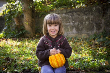 Portrait of smiling little girl with pumpkin - LVF002057