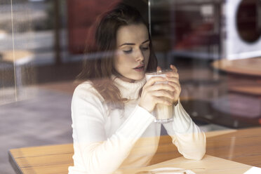Junge Frau mit Latte Macchiato in einem Cafe sitzend - GDF000510