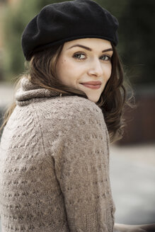 Portrait of smiling young woman wearing beret and knitted dress - GDF000498