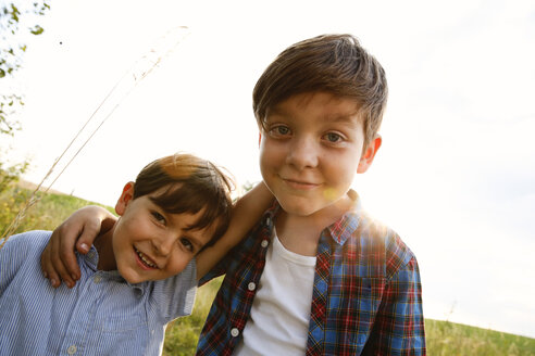 Porträt von zwei lächelnden kleinen Jungen bei Gegenlicht - FKIF000062