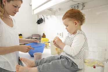 Mutter und kleine Tochter backen gemeinsam Kuchen in ihrer Küche - FSF000203