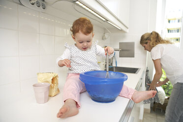 Mutter und kleine Tochter backen gemeinsam Kuchen in ihrer Küche - FSF000210