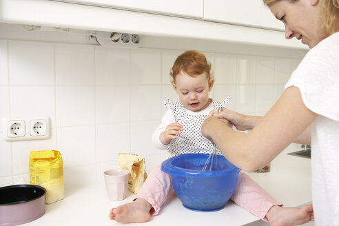 Mutter und kleine Tochter backen gemeinsam Kuchen in ihrer Küche - FSF000211