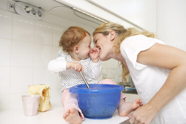 Mutter und kleine Tochter backen gemeinsam Kuchen in ihrer Küche - FSF000215