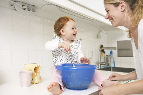 Mutter und kleine Tochter backen gemeinsam Kuchen in ihrer Küche - FSF000216