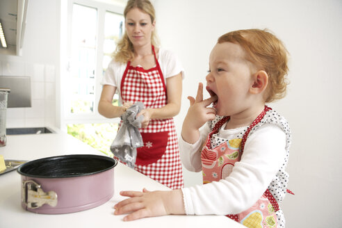 Mutter und kleine Tochter backen gemeinsam Kuchen in ihrer Küche - FSF000219