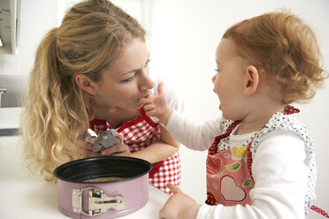 Mutter und kleine Tochter backen gemeinsam Kuchen in ihrer Küche - FSF000220