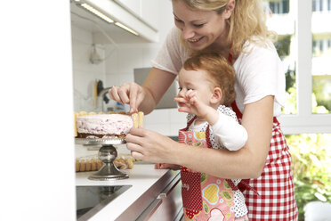 Mutter und kleine Tochter backen gemeinsam Kuchen in ihrer Küche - FSF000221