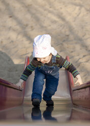 Kleines Mädchen klettert auf eine Rutsche auf dem Spielplatz - JFEF000468