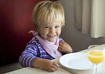 Portrait of happy little sitting at dining table - JFEF000474