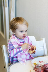 Little girl with bib trying to eat jam roll - JFEF000504