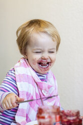Portrait of laughing little girl covered with red jam - JFEF000505