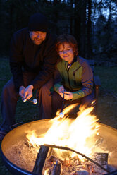 Vater und Sohn am Lagerfeuer und rösten Marshmallows - LBF000984