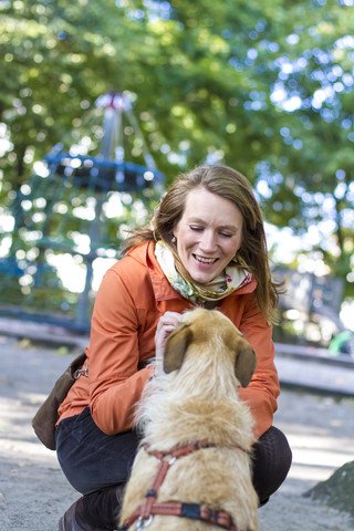 Porträt einer lächelnden Frau mit ihrem Hund, lizenzfreies Stockfoto