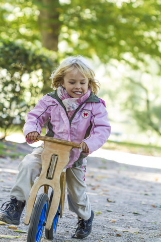 Kleines Mädchen fährt auf einem Balance-Fahrrad, lizenzfreies Stockfoto