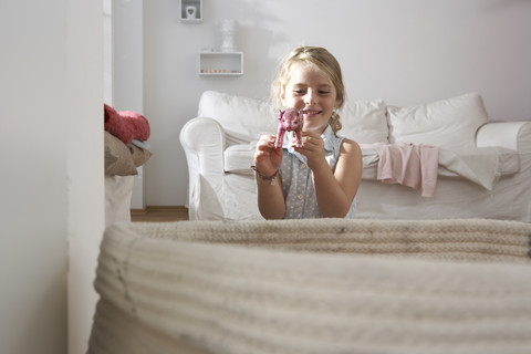 Mädchen zu Hause spielen mit Schwein Figurine, lizenzfreies Stockfoto