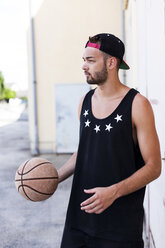 Young man with basketball wearing basecap - DAWF000173