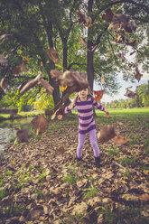 Little girl throwing autumn leaves - SARF000932