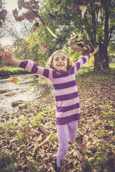 Little girl throwing autumn leaves - SARF000931