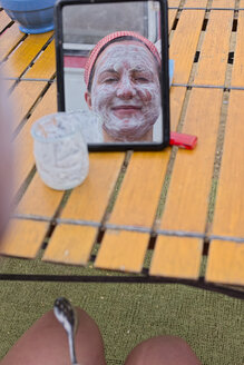 Frankreich, Bretagne, Finistere, Junge Frau trägt auf dem Campingplatz eine Gesichtsmaske aus Joghurt auf - LAF001153
