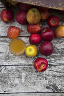 Glas mit Apfelsaft und roten Äpfeln auf Holz - LVF002070