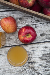 Glass of apple juice and red apples on wood - LVF002072