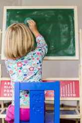 Little girl writing on blackboard - JFEF000464