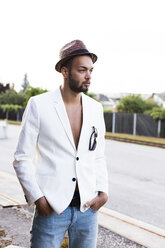 Young man wearing hat, sunglasses and white jacket on bare chest - DAWF000204