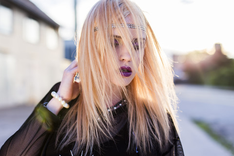 Porträt einer rauen blonden Frau mit Haarsträhnen im Gesicht, lizenzfreies Stockfoto