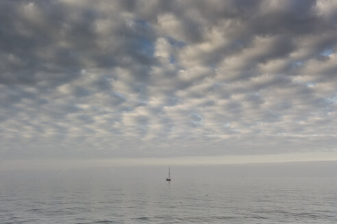 Deutschland, Ostsee, Segelboot ruht am Meer unter bewölktem Himmel - MELF000035